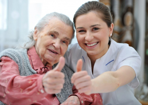 senior woman and female nurse are showing thumbs up